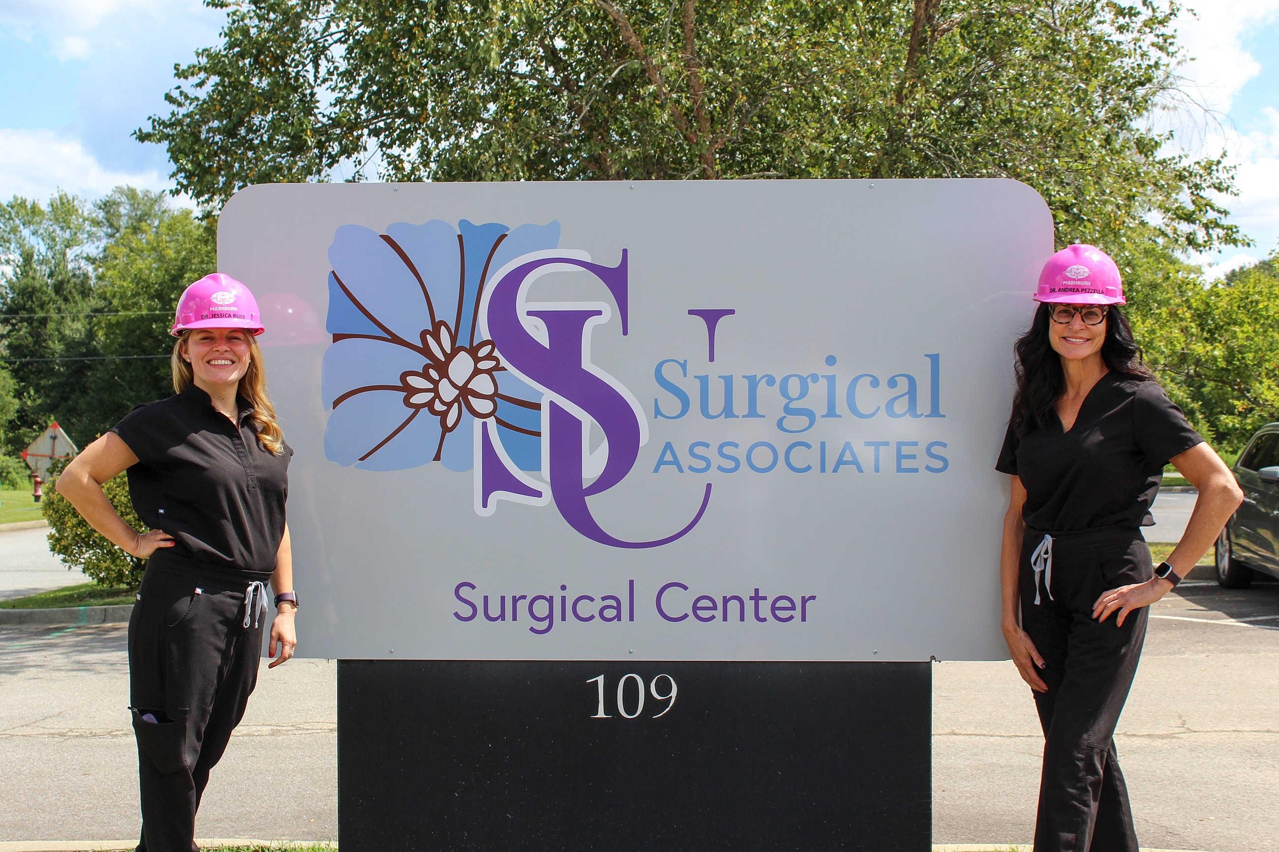 Two women in front of Surgical Associates sign.