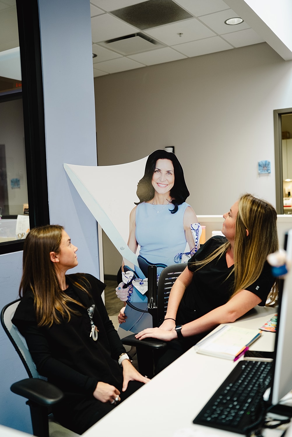 Two women interact with a life-sized cutout.