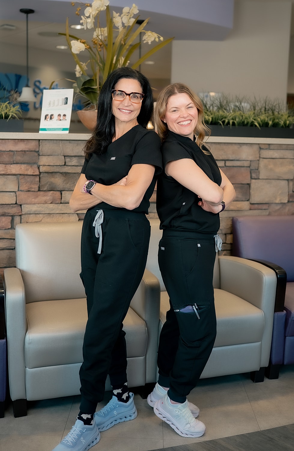 Smiling healthcare professionals in black scrubs.