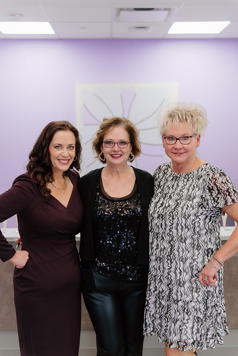 Three women posing in a modern interior.