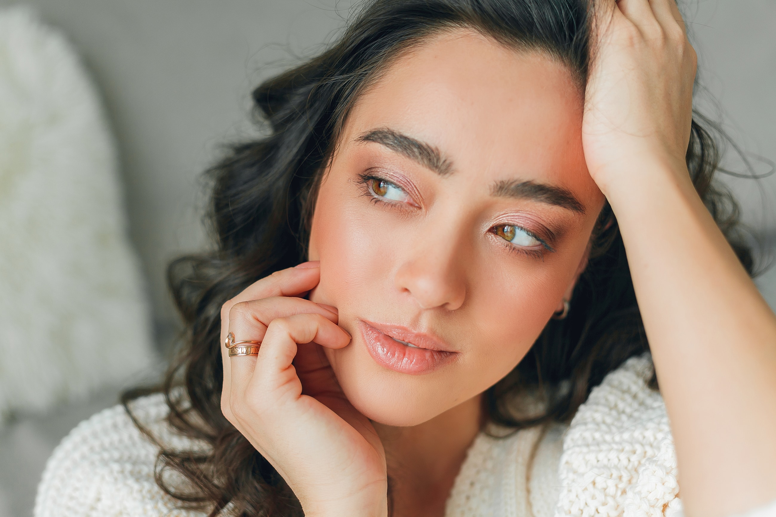 Woman in soft lighting with thoughtful expression.